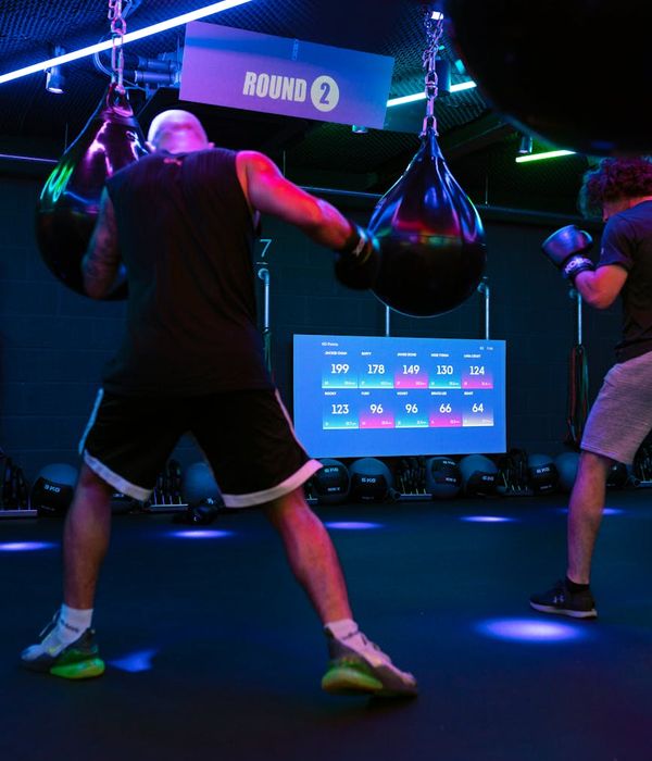 Man performing a controlled strength exercise in a dark, modern gym setting.